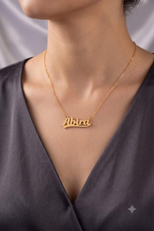 Bold script name necklace worn on model